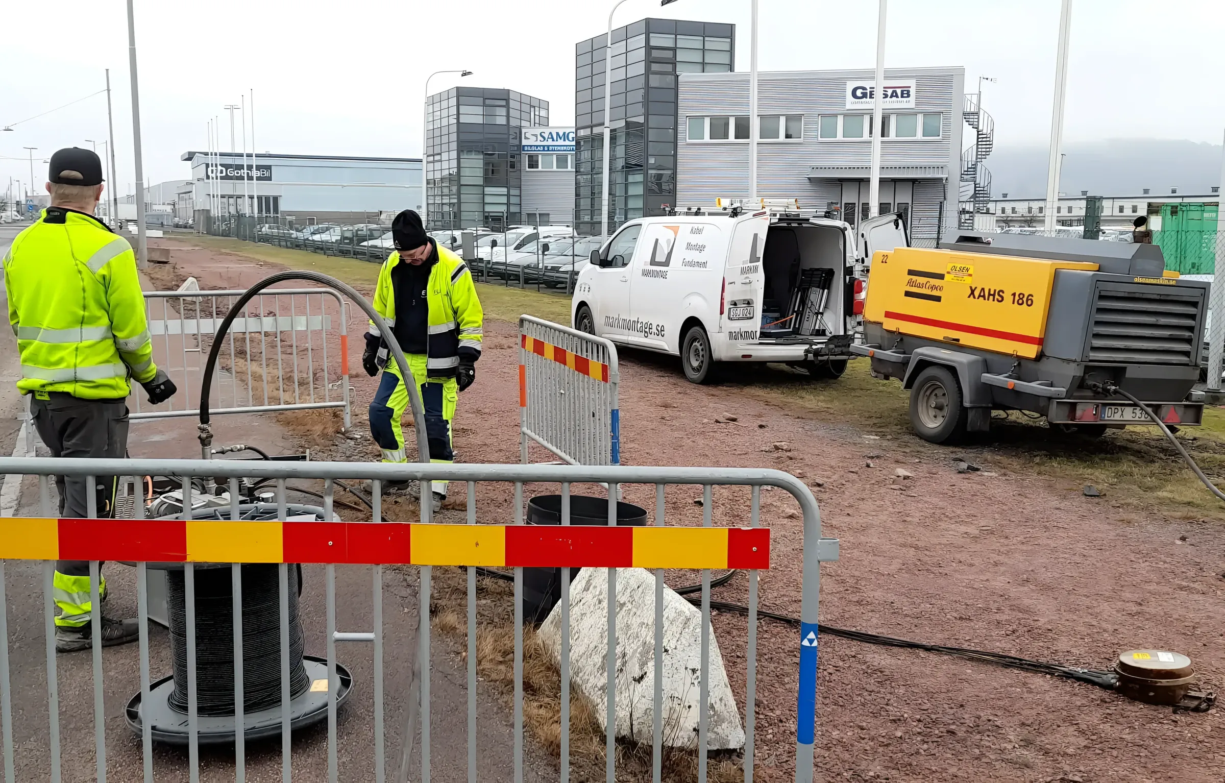 Medarbetare vid avspärrningen på en arbetsplats med servicebilar
