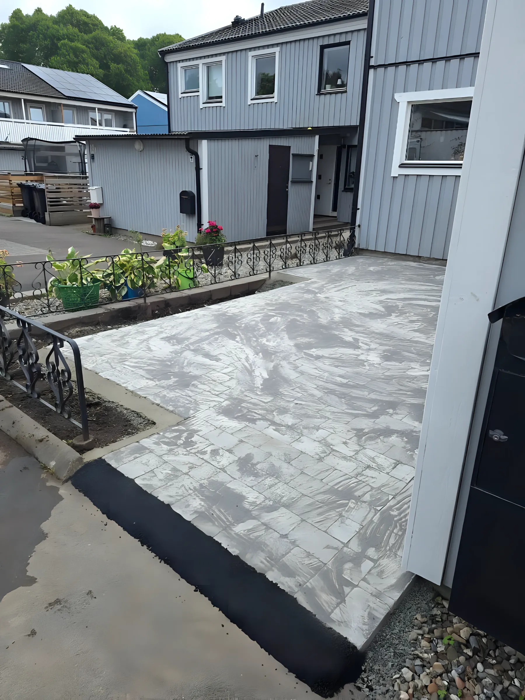 Färdig stenlagd gårdsplan framför ett hus